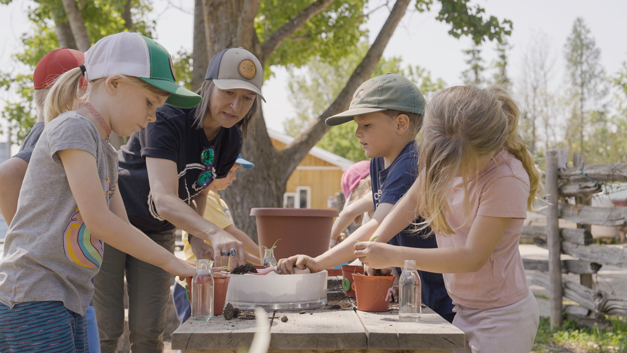 Teacher and students working with seedlings at an outdoor table — Kimbercote campus